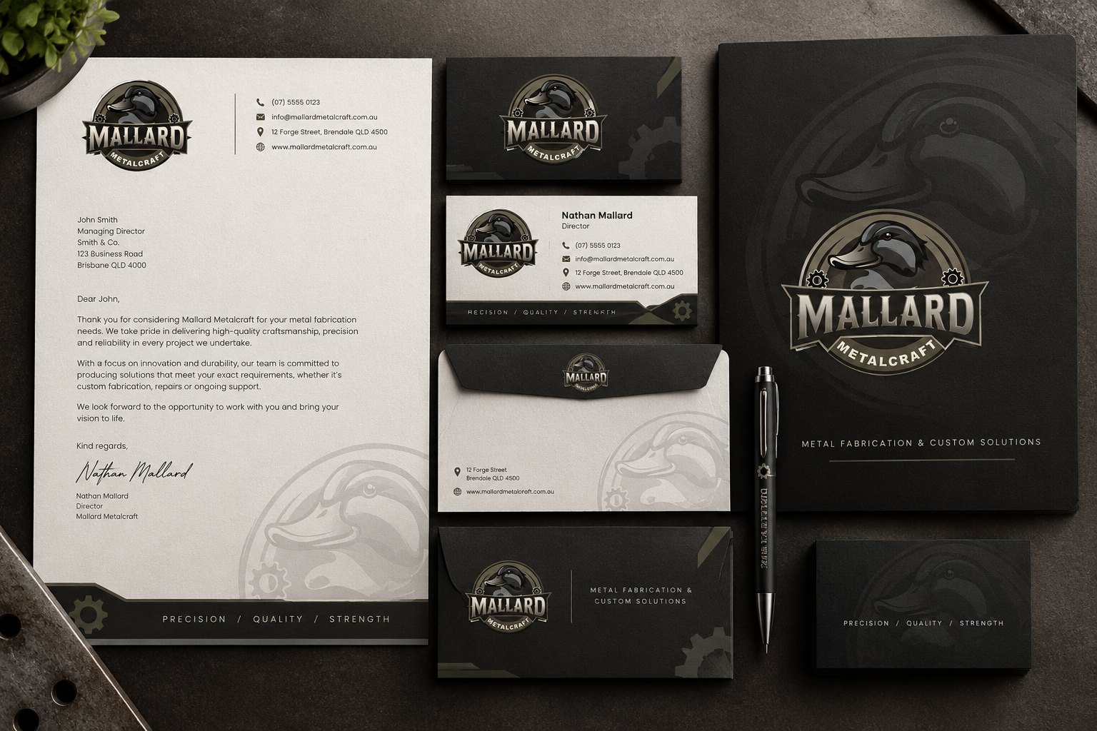 Mallard Metalcraft branding suite with letterhead, business cards, envelopes, folder and pen on a dark surface
