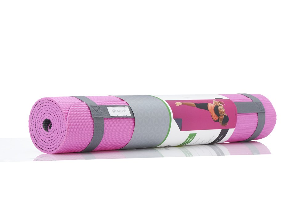 Rolled pink Gaiam yoga mat held with a grey strap and a printed product band